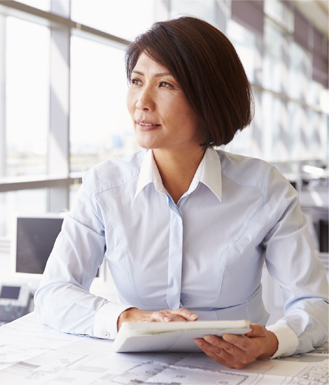 Femme à son bureau consultant un document